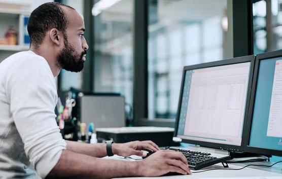 Man Working With Two Monitors