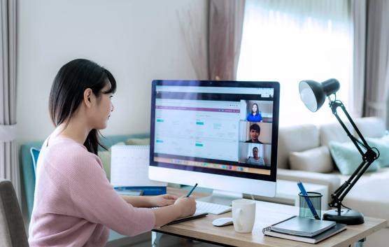 Woman Taking Notes During Online Call