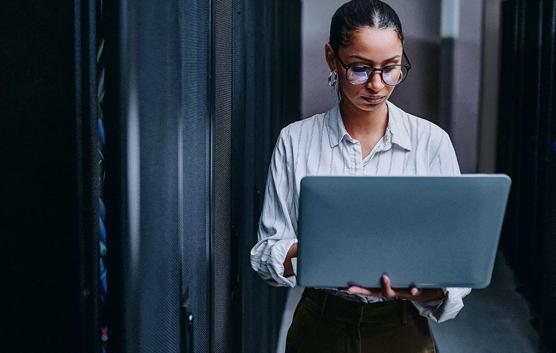 Femme sur un ordinateur portable dans le datacenter