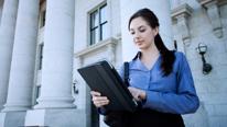 Woman Working on Tablet in Front of Government Building