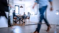 People Walking in Front of Meeting in Conference Room