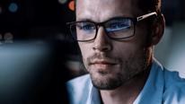 Portrait d’un entrepreneur de startup numérique travaillant sur ordinateur, ligne de code reflétée dans ses lunettes.Développeur travaillant sur une application de commerce électronique innovante utilisant un algorithme d’IA et le Big Data.