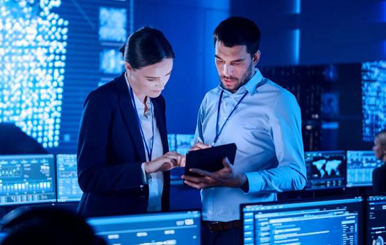 Man and Woman Looking At Tablet in Control Room