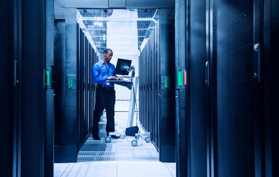 Black businessman using computer in server room