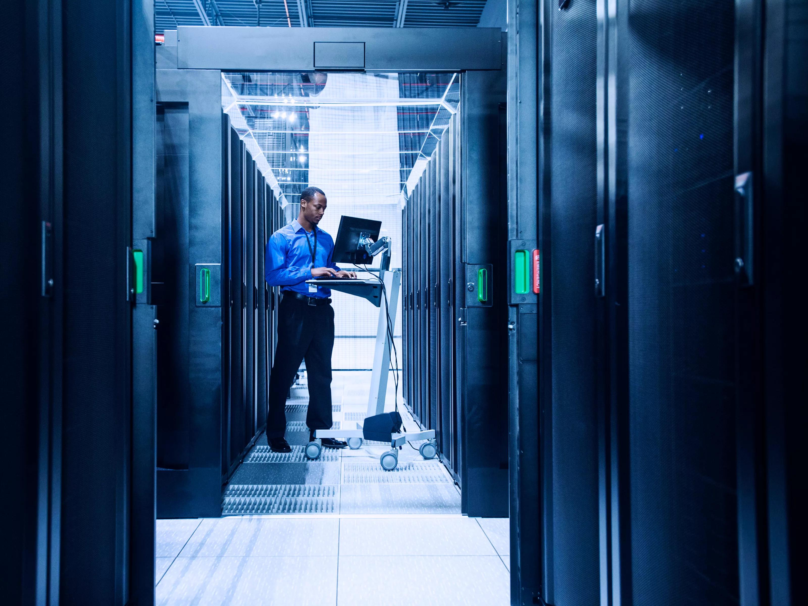 Black businessman using computer in server room