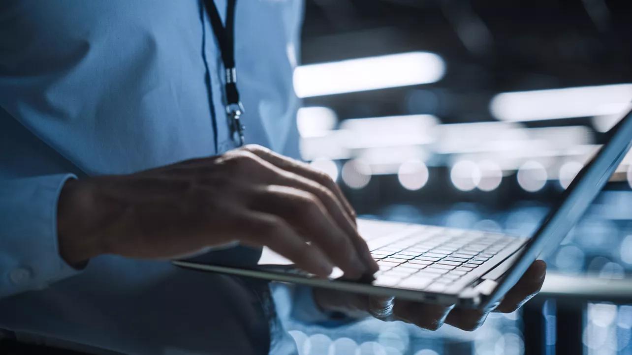 Main d’homme sur un clavier d’ordinateur portable