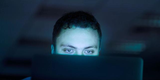 Man Looking at Computer Screen at Night
