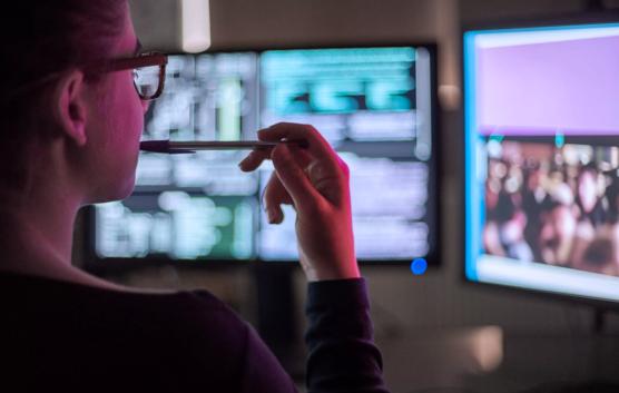 Close-Up of Woman Looking Two Computer Monitors