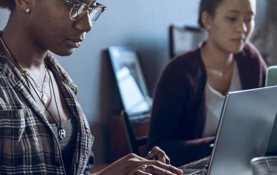 Two Women Working on Laptops in Office