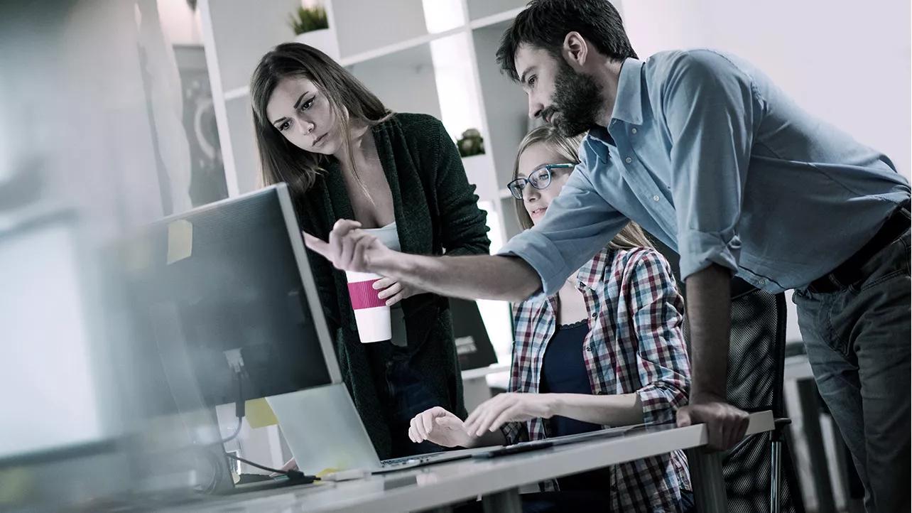 Man Pointing at Screen With Colleagues