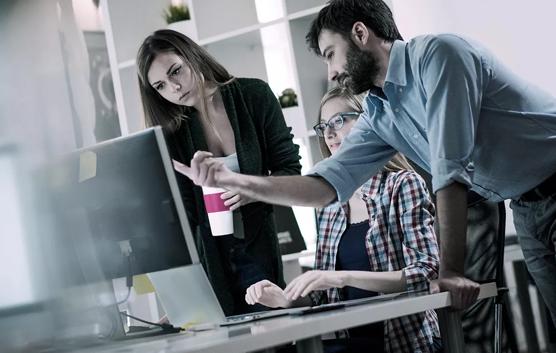 Man Pointing at Screen With Colleagues