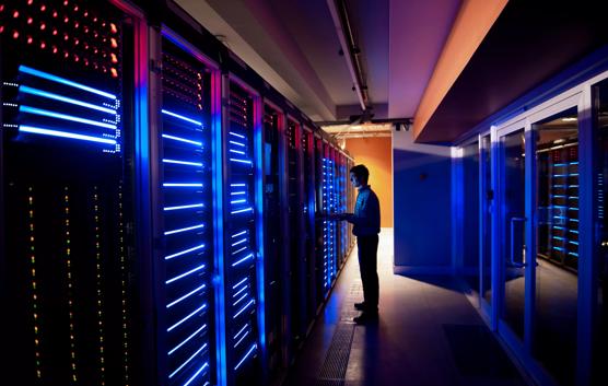 Engineer on Laptop in Modern Data Center