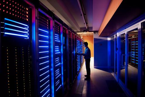 Engineer on Laptop in Modern Data Center