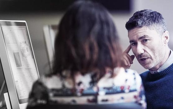 Man and Woman Talking by Computer Screen