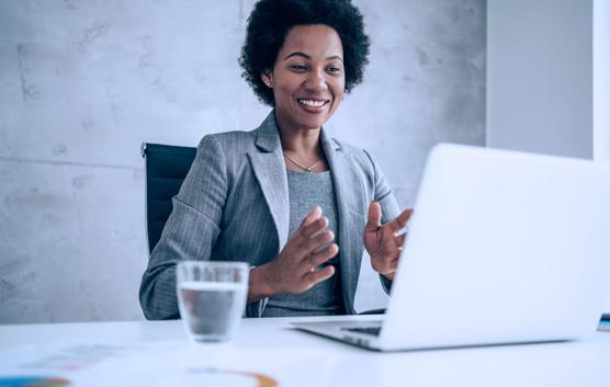 Attractive african-american businesswoman having video call with her coworkers. Businesswoman having important online conversation with customer. Shot of a young woman using a laptop for video conference. Smiling businesswoman in a video call using laptop in the office.