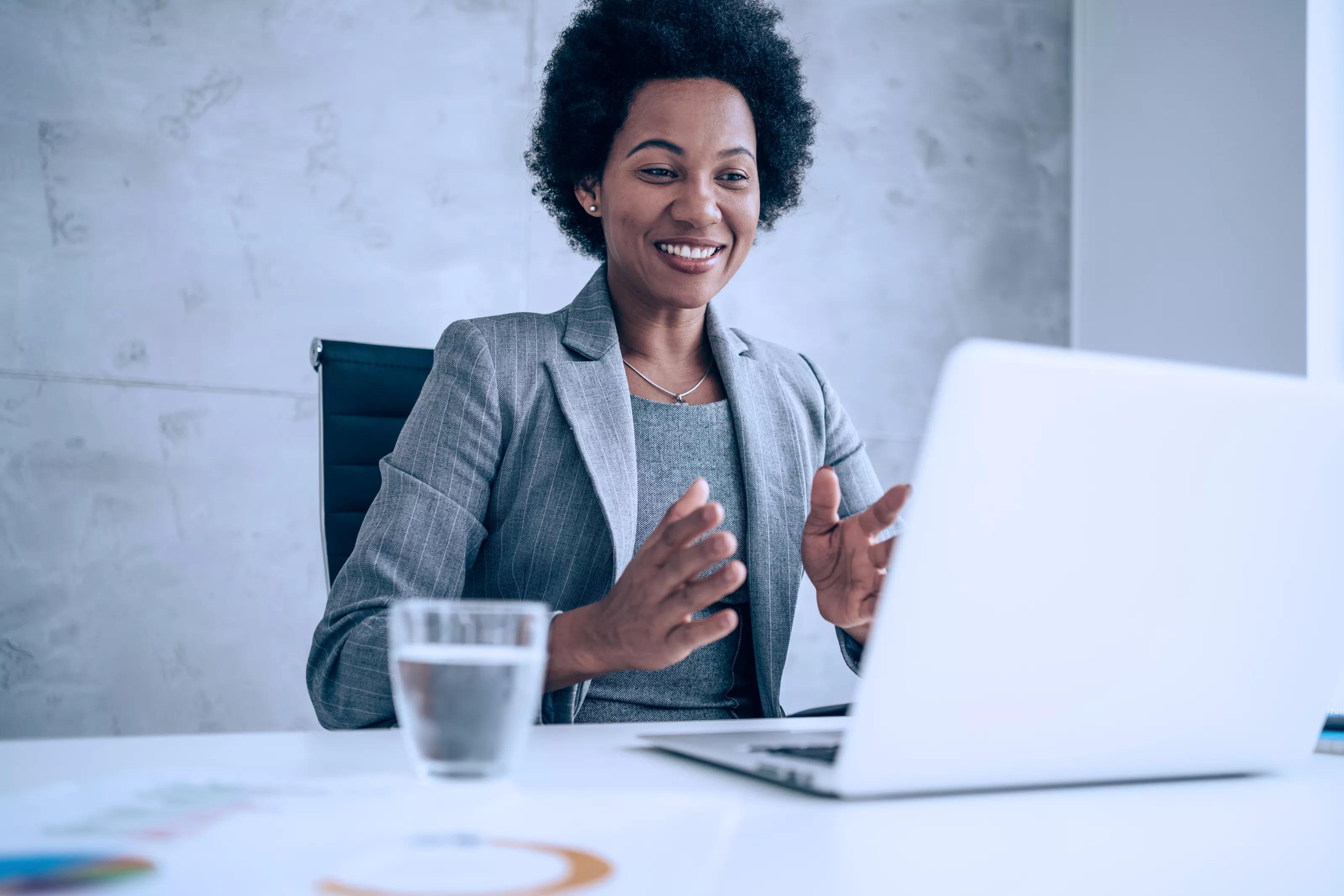 Attractive african-american businesswoman having video call with her coworkers. Businesswoman having important online conversation with customer. Shot of a young woman using a laptop for video conference. Smiling businesswoman in a video call using laptop in the office.