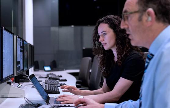 Man and Woman Working on Laptop and Computer Screens