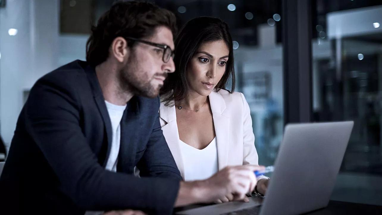 Man and Woman Looking At Laptop