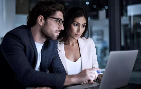 Man and Woman Looking At Laptop